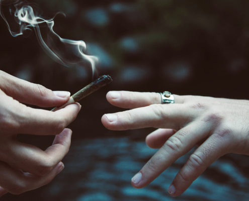Friends passing a joint to one another