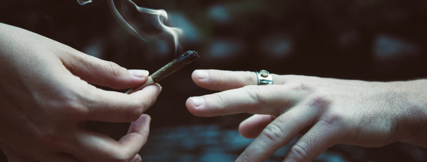 Friends passing a joint to one another