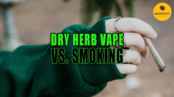 Woman wearing rings and a forest green sweater smoking a joint